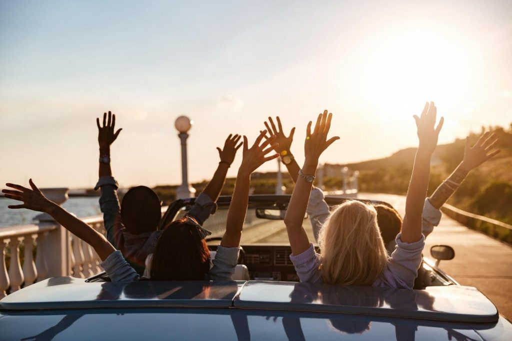 Young People With Hands Up in Car